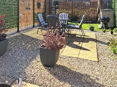 a patio with chairs and a plant in a pot at Miners Cottage in Girvan