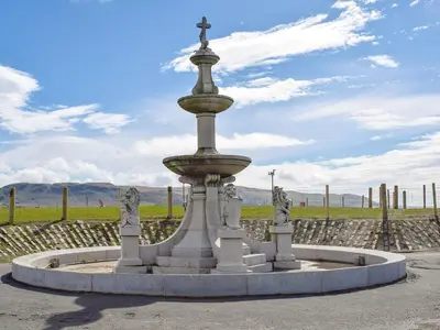 a fountain with a cross on top of it at Miners Cottage in Girvan