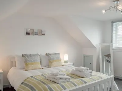 a bedroom with a bed with towels on it at Miners Cottage in Girvan