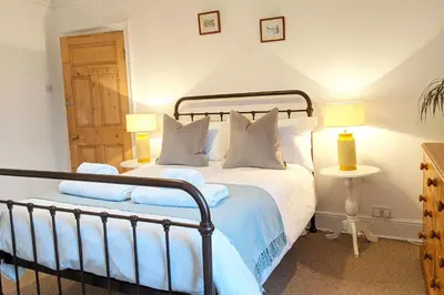 a bedroom with a large bed with two lamps at Townhouse Apartment Carlisle in Carlisle