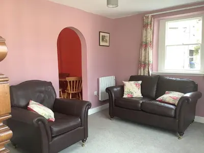 a living room with two leather chairs and a couch at The Coach House, Hesket Newmarket in Hesket Newmarket