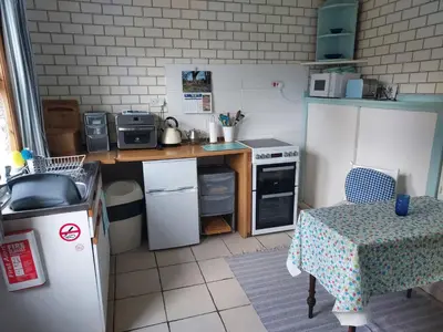 a small kitchen with a table and a stove at BARHOLM CROFT Holiday Cottage in Creetown