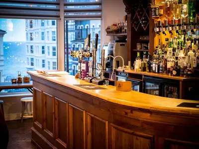 a bar with a wooden counter and a window at Mereside in Douglas
