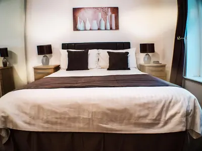a bedroom with a large bed with two lamps at Mereside in Douglas