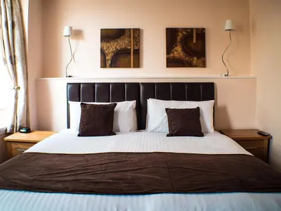 a bedroom with a large bed with two pillows at Mereside in Douglas