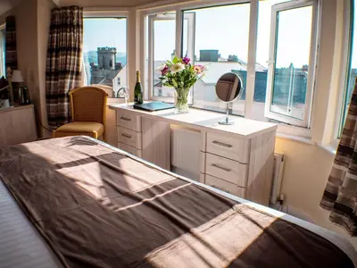 a bedroom with a bed and a vase of flowers on a counter at Mereside in Douglas