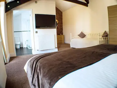 a bedroom with a bed and a flat screen tv at Mereside in Douglas