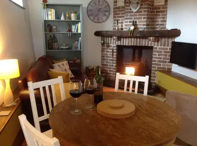 a dining room table with wine glasses and a fireplace at The Hayloft. Entire Barn Conversion near Keswick in Applethwaite