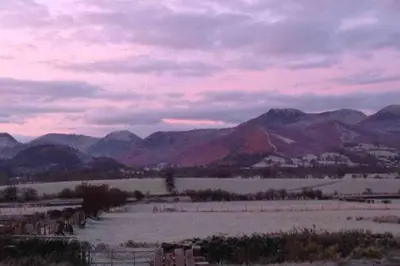 a view of a field with mountains in the background at The Hayloft. Entire Barn Conversion near Keswick in Applethwaite