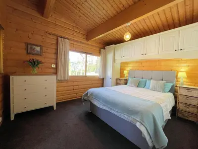 a bedroom with a bed and a wooden ceiling at Beautiful Norwegian Lodge in Kippford with Garden - Pass the Keys in Dalbeattie