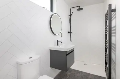 a white bathroom with a sink and a mirror at Snowdrop, Penruddock an Eco and dog friendly lodge with hot tub, 10 minutes to Lake Ullswater in Penruddock