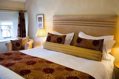 a hotel room with a large bed and a window at Porch Cottage, a luxurious characterful cottage within walking distance of Keswick town centre in Keswick