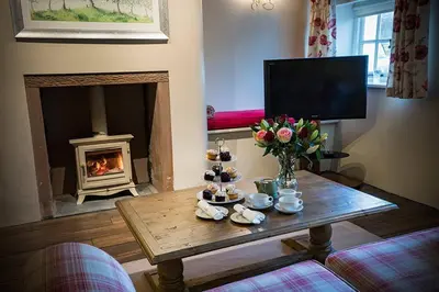 a living room with a coffee table and a fireplace at Porch Cottage, a luxurious characterful cottage within walking distance of Keswick town centre in Keswick