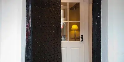 a door with a mirror and a lamp in a room at Porch Cottage, a luxurious characterful cottage within walking distance of Keswick town centre in Keswick