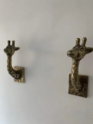 two metal giraffe decorations on a wall at The Apartment, Bridge House in Laxey