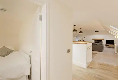 a white bedroom with a bed and a living room at Stroan in New Galloway