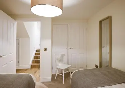 a bedroom with a bed and a chair and a lamp at Stroan in New Galloway