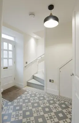 a hallway with white walls and a staircase and a floor at Stroan in New Galloway
