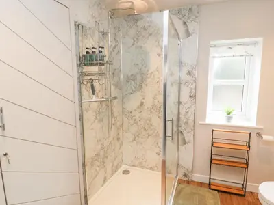 a shower with a glass door in a bathroom at The Flat in Carlisle