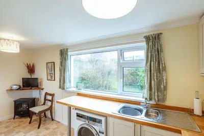 a kitchen with a sink and a window at Foxbrae Cottage in Rockcliffe
