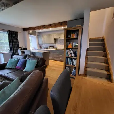 a living room with a couch and a book shelf at 1 Bridge Syke Elterwater in Ambleside