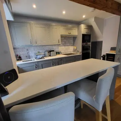 a kitchen with a counter and some chairs in it at 1 Bridge Syke Elterwater in Ambleside