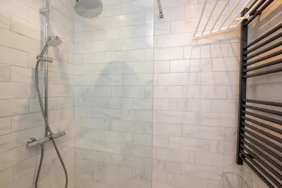 a bathroom with a shower with white tiles at 1 Bridge Syke Elterwater in Ambleside