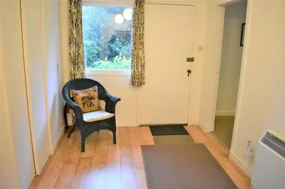 a hallway with a chair with a pillow on it at Glenauld Cottage in Kirkcudbright
