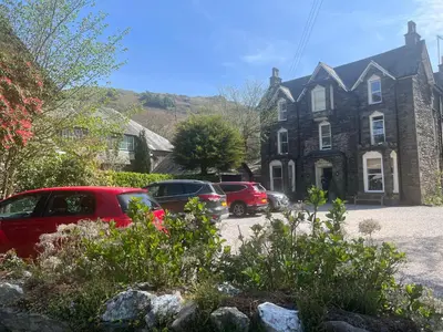 a house with cars parked in front of it at The Grasmere Hotel in Grasmere