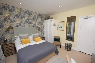 a bedroom with a large bed with yellow pillows at The Grasmere Hotel in Grasmere