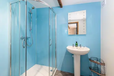 a bathroom with a glass shower and a sink at Cosy Glamping In the Eskdale Valley - Studio Lodges and Mega Pods in Eskdale