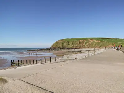 a group of people walking on the beach at Seaspray in St Bees
