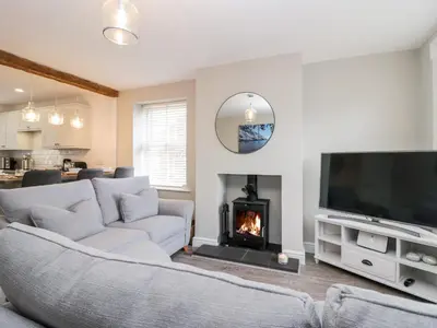 a living room with a couch and a fireplace at Wainwright Cottage in Seascale