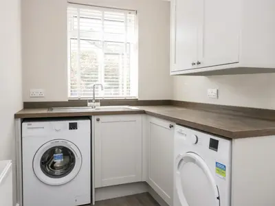 a kitchen with a washing machine and a sink at Wainwright Cottage in Seascale