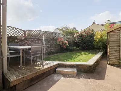 a patio with a table and chairs in a backyard at Wainwright Cottage in Seascale