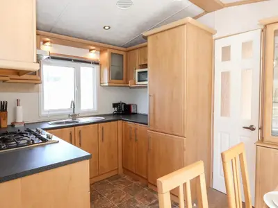 a kitchen with wooden cabinets and a counter top at Whiteside in Cockermouth