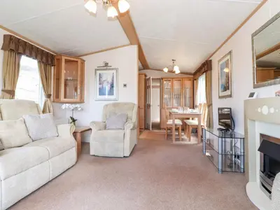 a living room with a couch and chairs and a tv at Whiteside in Cockermouth
