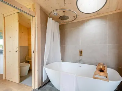 a large tub in a bathroom with a toilet at The Curve At Caerlaverock Estate in Glencaple