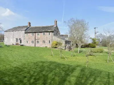 an old brick house on a green field at Rushgill House in Sebergham