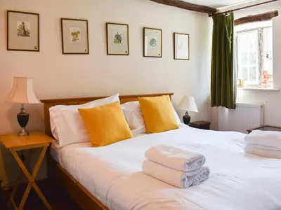 a bedroom with a large white bed with yellow pillows at Rushgill House in Sebergham