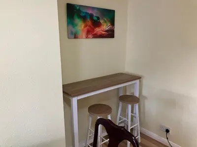a table in the corner of a room with two stools at Bells yard Cottage Maryport in Maryport