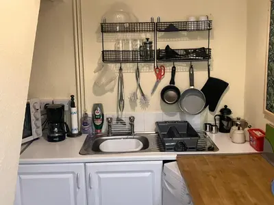 a kitchen with a sink and a stove and utensils at Bells yard Cottage Maryport in Maryport