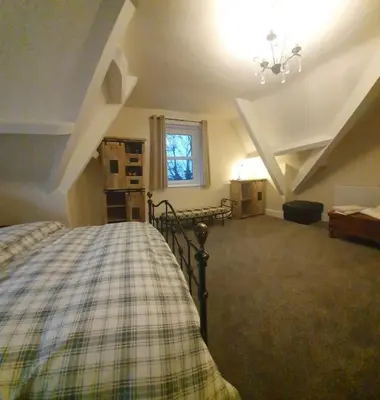 a bedroom with a bed in a attic at Eta's Manor @ Brooklands in Maryport