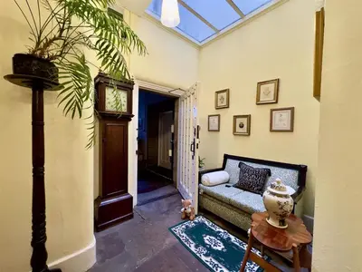 a living room with a couch and a clock at Calthwaite Hall Bed & Breakfast in Penrith