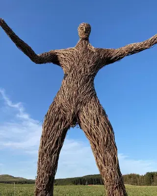 a statue of a man with his arms outstretched at Serendipity in Kirkcudbright
