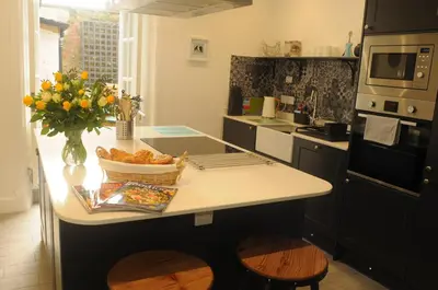 a kitchen with a counter with a vase of flowers at Serendipity in Kirkcudbright